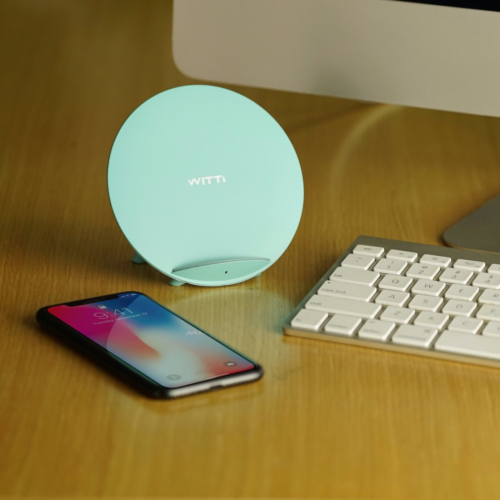 tiffany blue candy wireless charging station on desk next to phone