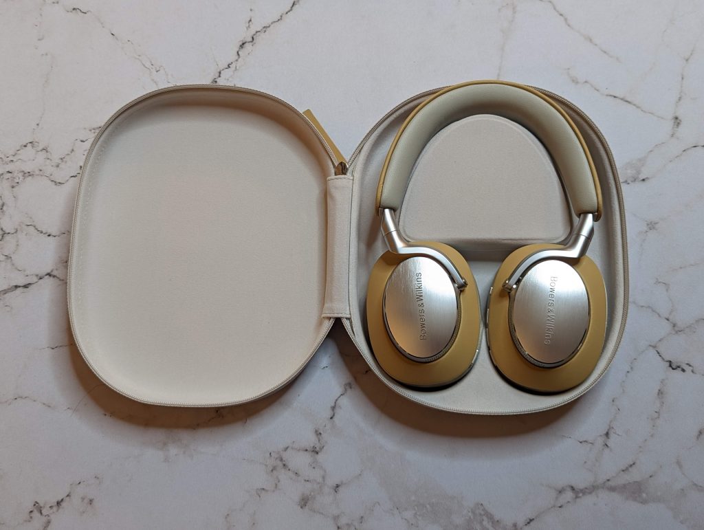 bowers and wilkins over the ear headphones in the tan color, in the carrying case.